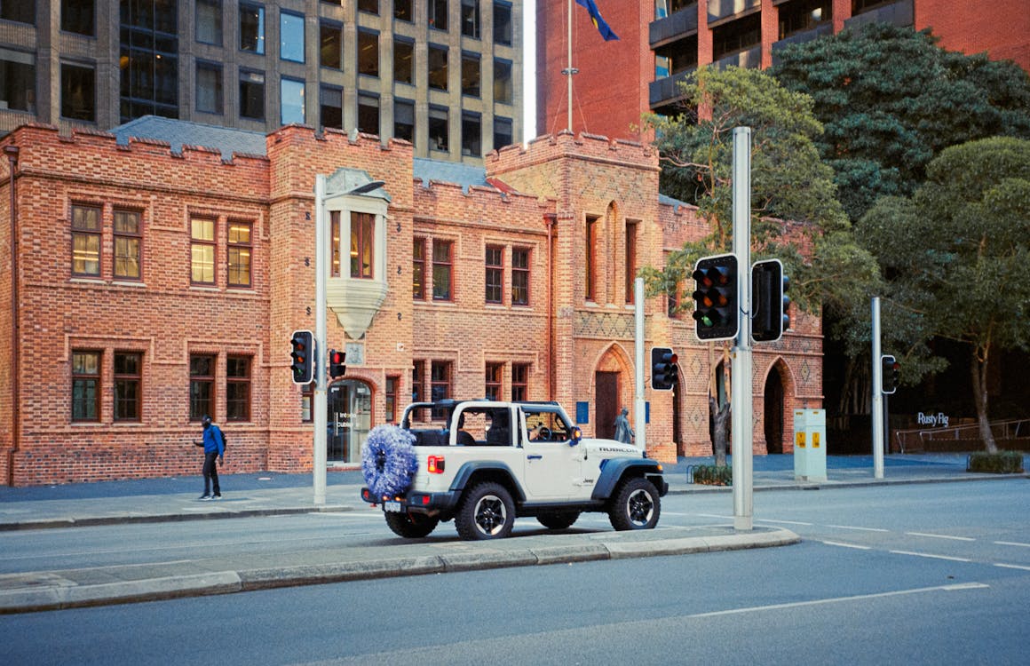 A jeep driving down a street in front of a building