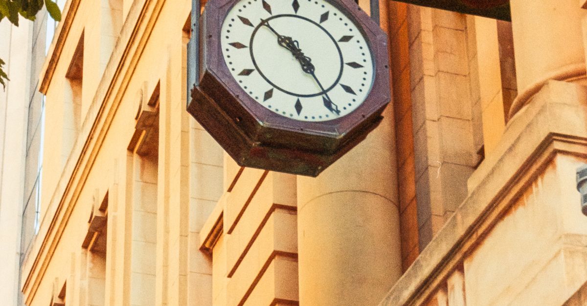Clock Building Clock A clock on the side of a building with a building in the background ...