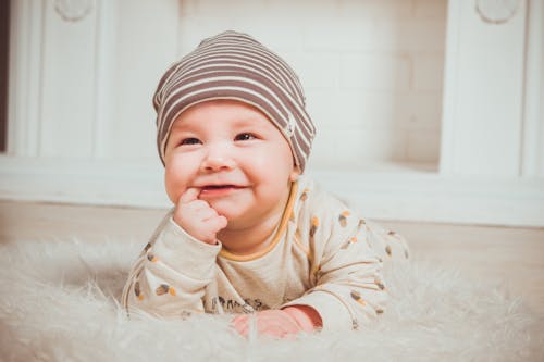 무료 웃는 아기 물고 오른쪽 검지 손가락 스톡 사진