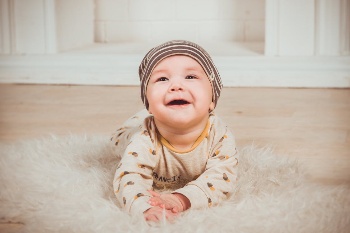 Free Baby Lying On White Fur Textile Stock Photo