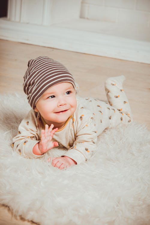 Free Smiling Baby Lying on White Mat Stock Photo