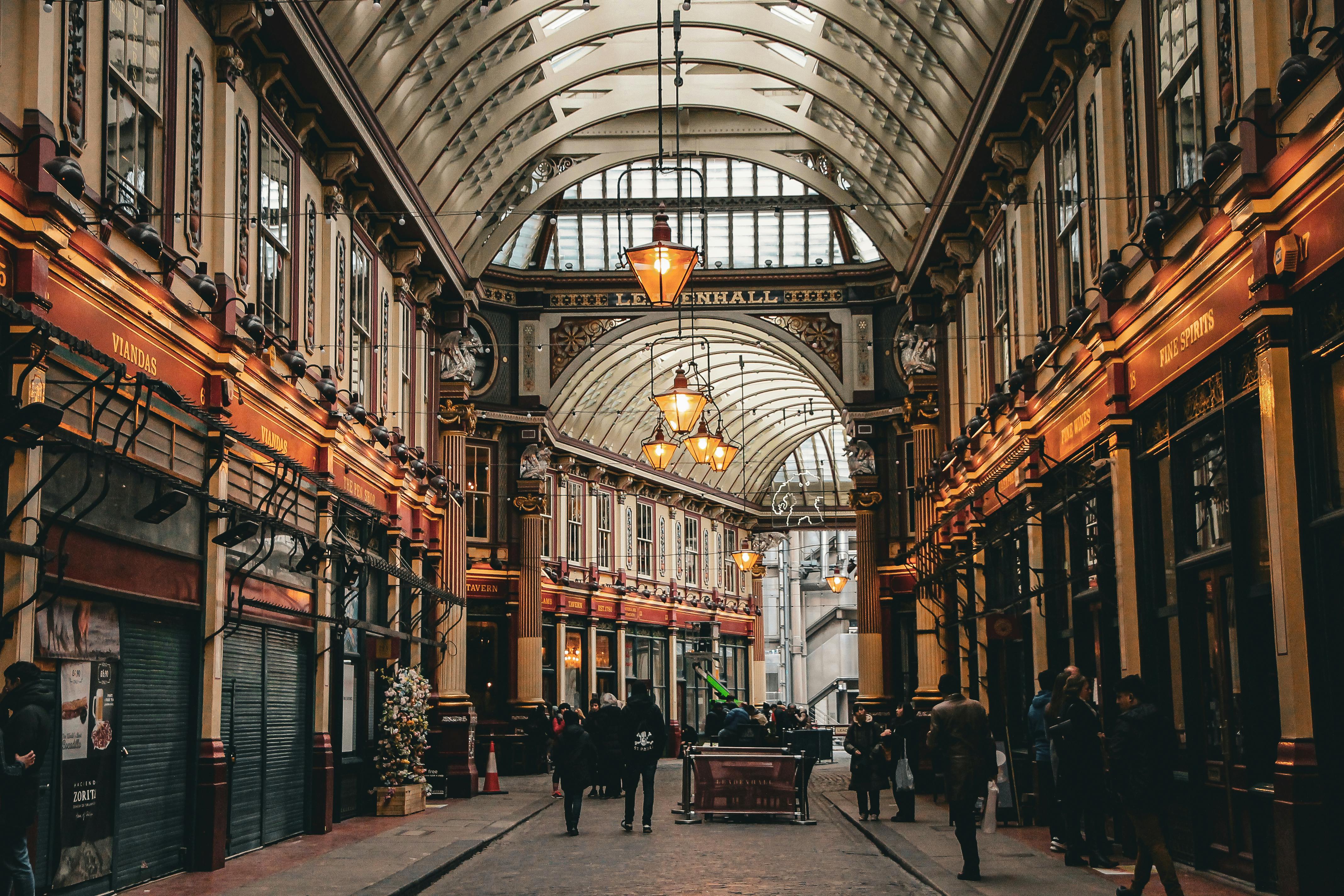 Historic Leadenhall Market in London bustling with tourists and vibrant lighting.