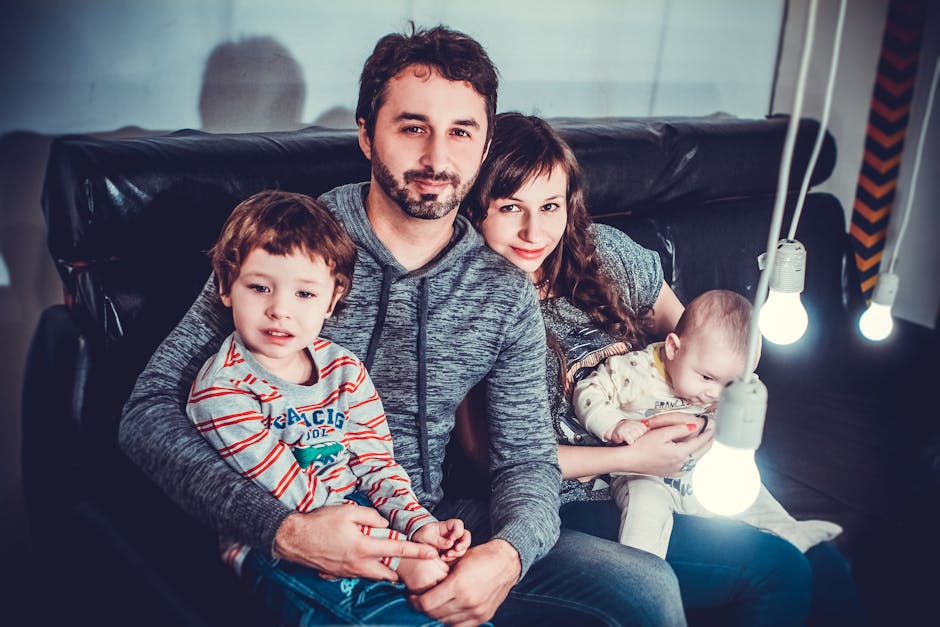 A joyful family of four sitting on a sofa