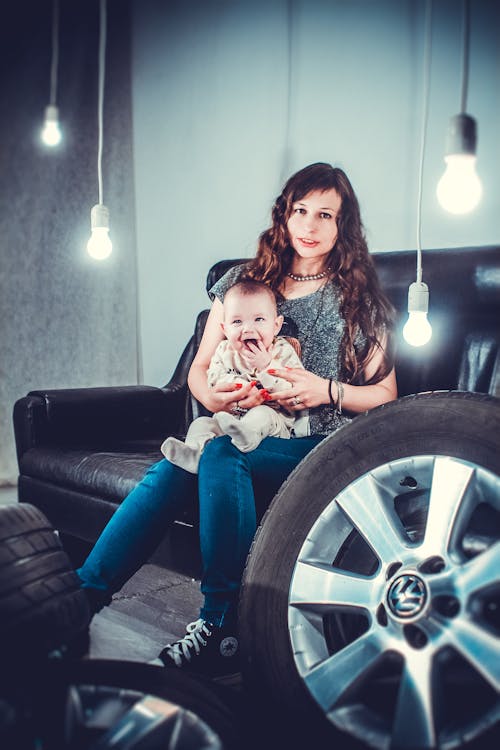 Free Photo of Laughing Baby Sitting on Mother's Lap Stock Photo