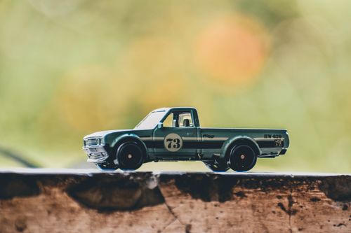 Free Close-up of a vintage toy truck captured with soft focus on a rustic surface outdoors. Stock Photo