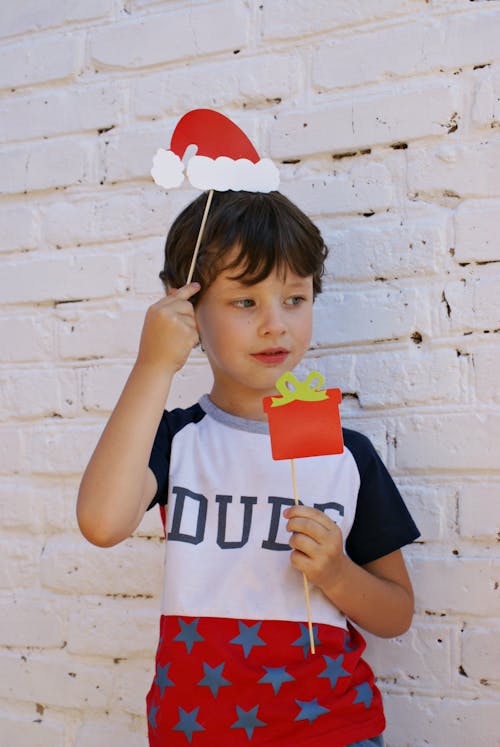 Foto Di Un Ragazzo Che Tiene La Cartolina Di Natale Rossa