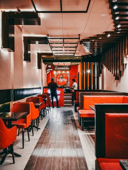 Stylish modern restaurant interior with vibrant red chairs and booths, creating a lively dining atmosphere.