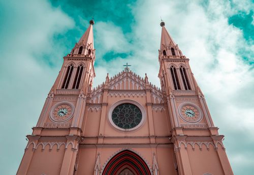 Free Striking neogothic church facade with twin spires against a dramatic sky, symbolizing spirituality. Stock Photo