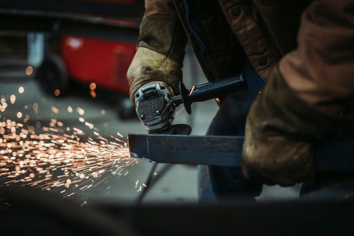 Tradesperson cutting steel for a structural assembly