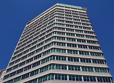 Low angle view of a modern office building against clear blue sky.