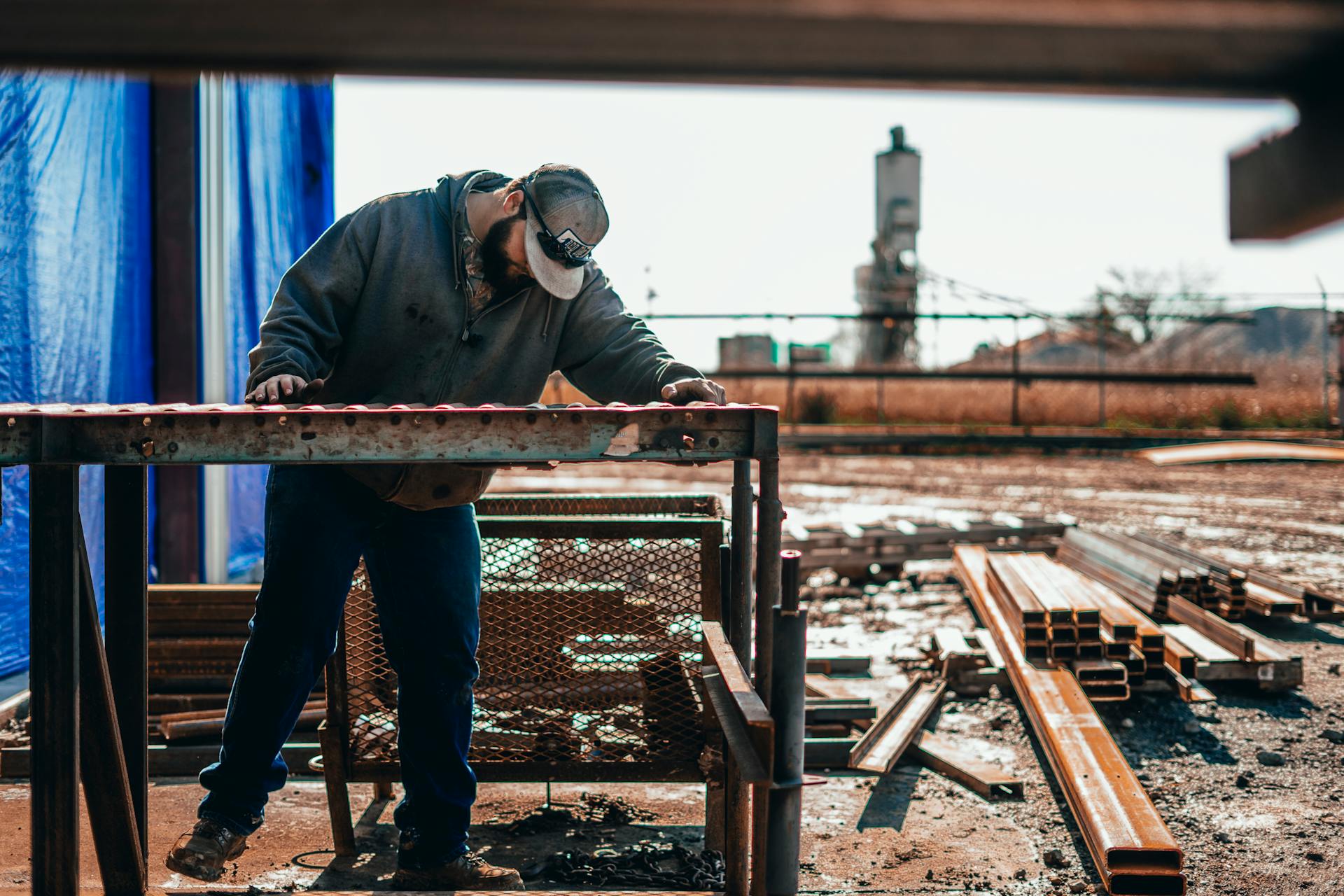 A male worker focuses on assembling steel structures at an outdoor construction site.