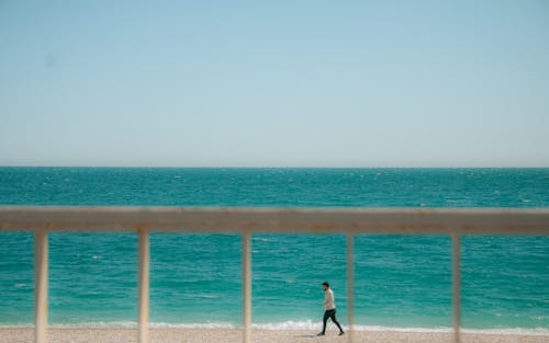 Man on a Stroll along Blue Sea