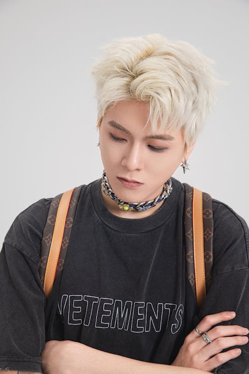 Young Man with Dyed Platinum Blond Hair Posing in Studio 