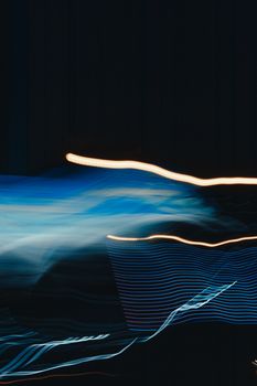 Dynamic abstract image featuring motion blur and blue light streaks on a dark background.