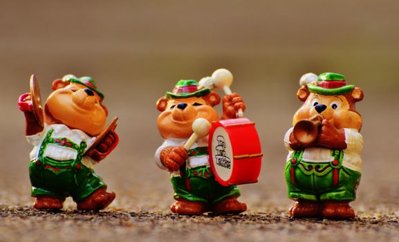 Three adorable bear figurines dressed as musicians in traditional costumes playing music instruments.