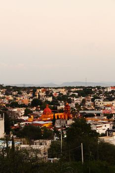 Peaceful aerial view of colorful Bernal town in Mexico at dusk, showcasing vibrant architecture.