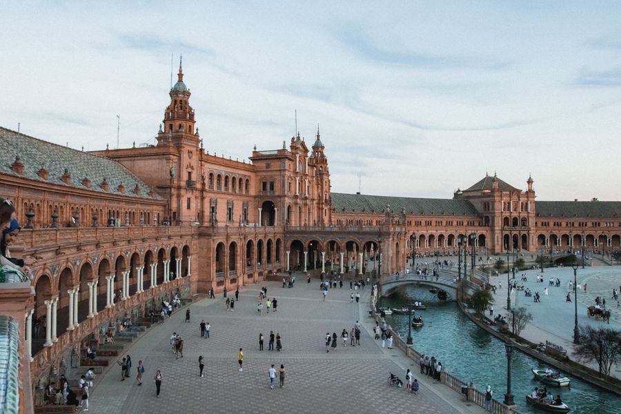 Clădiri impunătoare pe Plaza de España din Sevilla, arhitectură cu arce și cărămidă