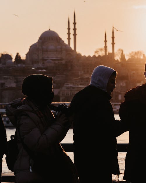 Silhouettes of a Group on a Bridge next to a Temple