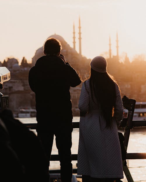 Silhouettes of a Group on a Bridge next to a Temple