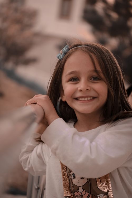 Free A joyful young girl smiling warmly in an outdoor autumn setting. Stock Photo