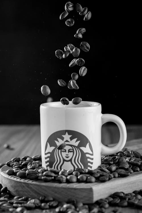 Coffee Beans Falling into Starbucks Mug