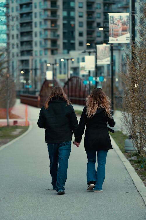 Young Women on Sidewalk Holding Hands