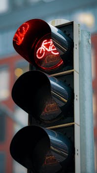 Close-up of a red bicycle traffic light in the city, signaling stop.