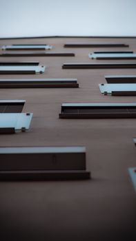 A low angle view of a modern residential building facade with multiple windows.