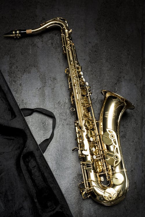 gratis Messing Saxofoon Op Grijze Tafel In De Buurt Van Zwarte Tas Stockfoto