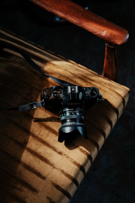 Retro camera resting on a velvet chair, highlighting vintage photography equipment.