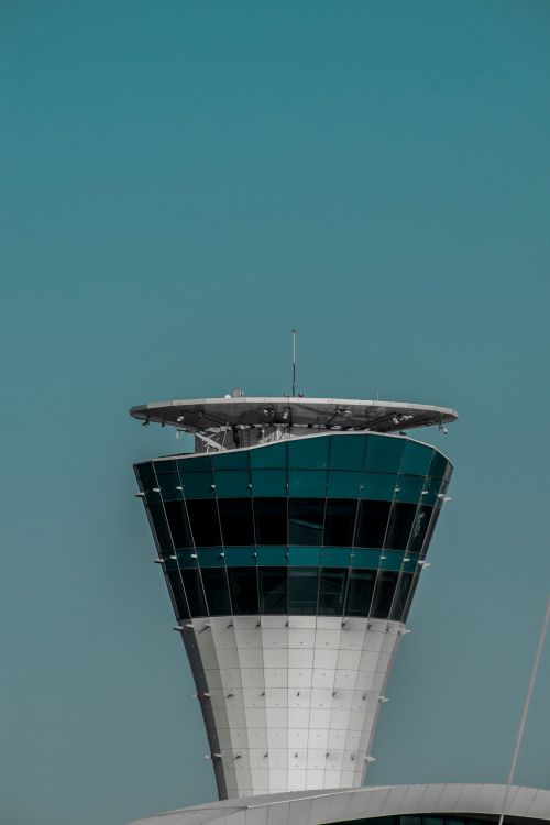 Free A striking view of the modern architecture of a control tower in Dubai against a clear sky. Stock Photo