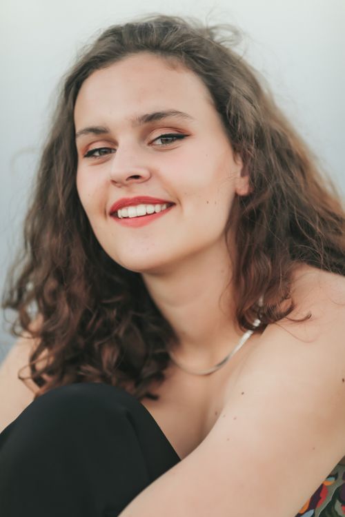Free A close-up portrait of a smiling woman with brown hair and a relaxed pose. Stock Photo