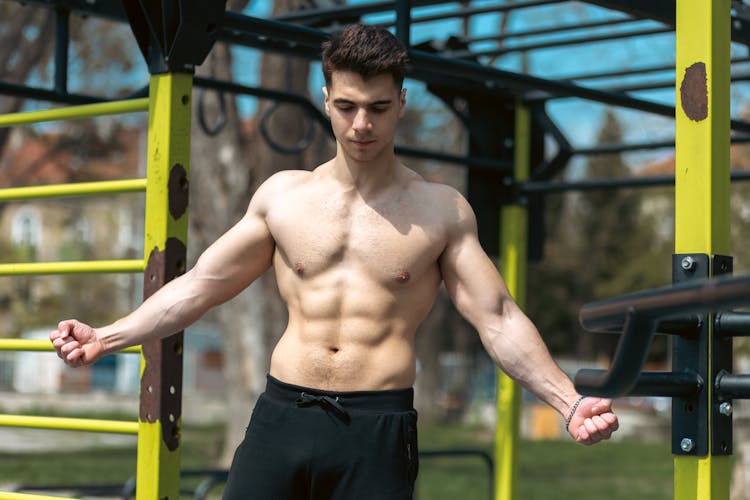 Muscular Model Posing In Outdoor Gym