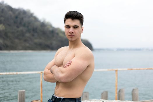 Muscular Shirtless Man Posing on the Shore 