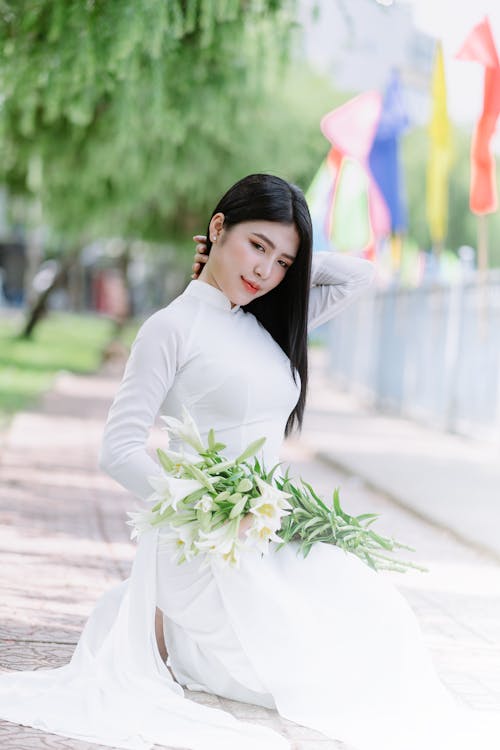 Woman Sitting and Posing in Wedding Dress