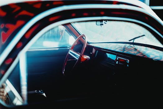 Classic car interior showcasing a retro dashboard and steering wheel under soft natural light.