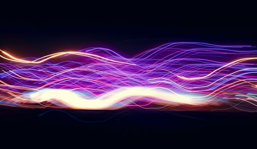 Free Colorful and dynamic light trails create an abstract pattern against a dark backdrop. Stock Photo