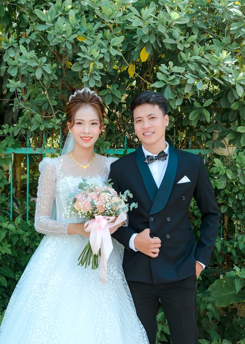 Free A joyful couple in wedding attire posing outdoors. Vibrant and romantic setting. Stock Photo