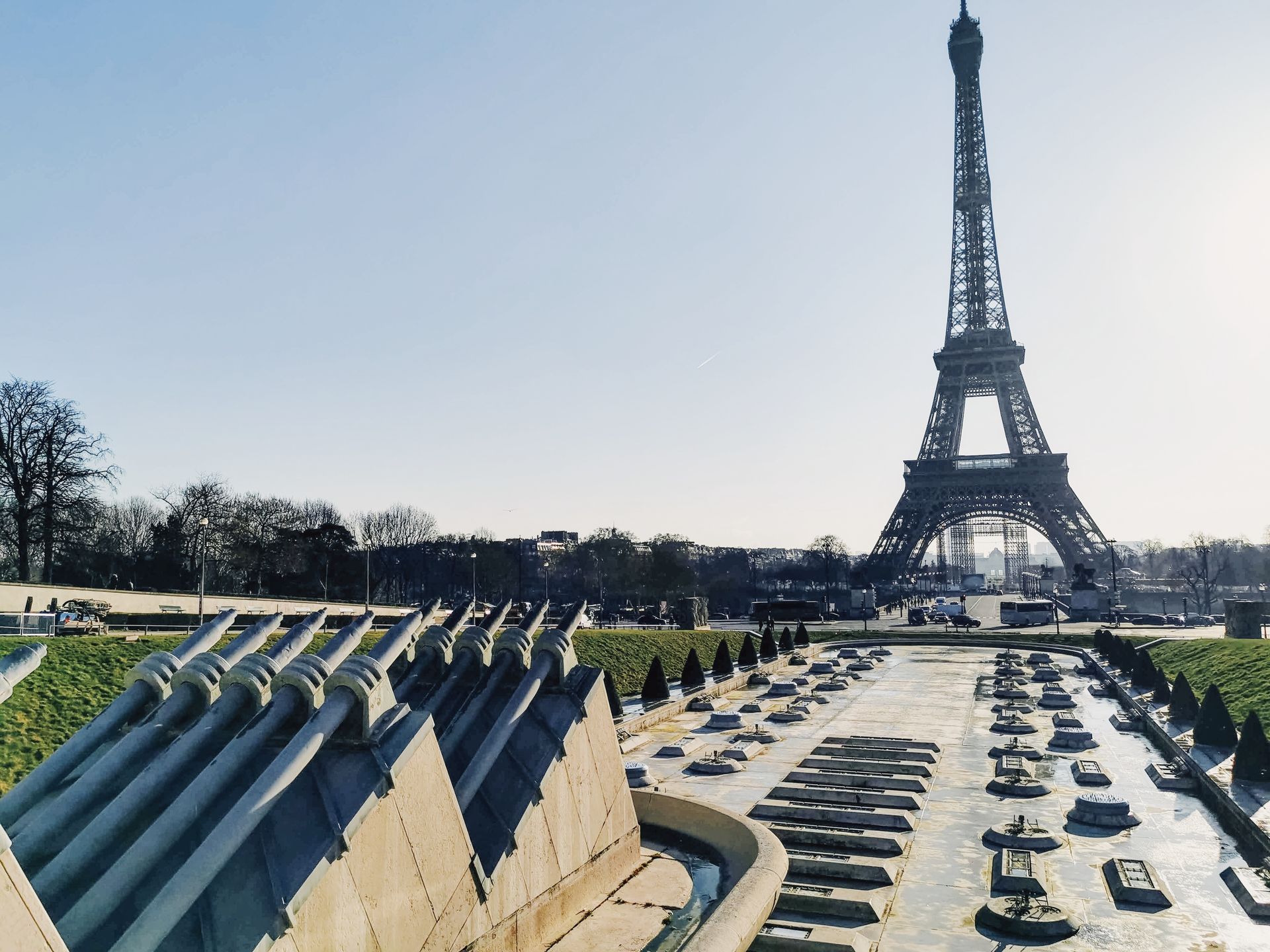 The iconic Eiffel Tower with the Trocadéro fountains under a clear blue Parisian sky.