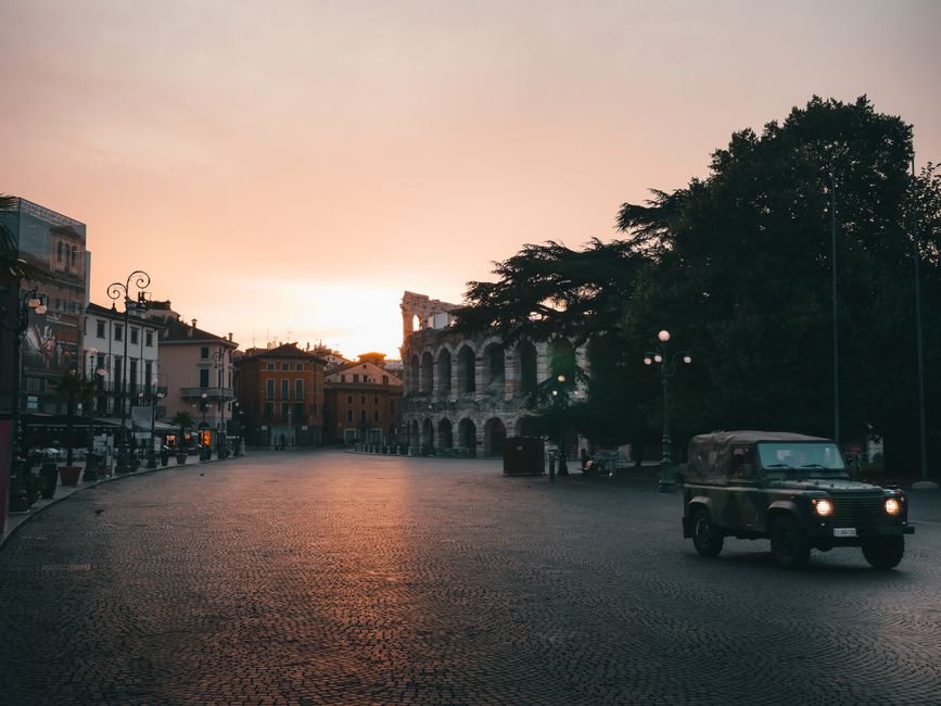 Beautiful sunset over Piazza Bra in Verona, featuring the ancient Roman Arena. A calm urban scene.