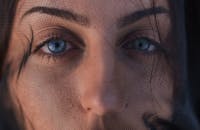 一位女士的有趣特写，她有着引人注目的蓝眼睛和面纱