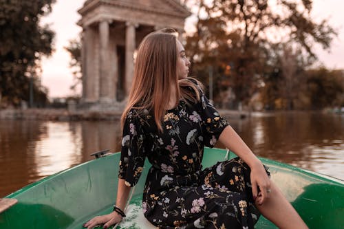 Free Woman in Black Dress Riding Boat Stock Photo