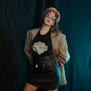 一位年轻时尚的女子在室内戴着太阳镜，穿着复古服装摆姿势