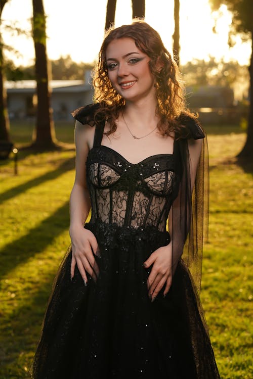 Young Woman in a Black Dress Standing Outdoors 