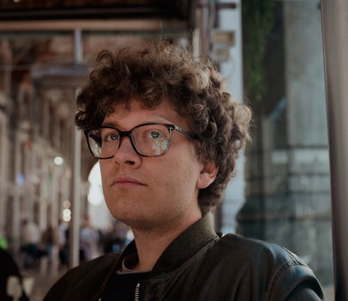 Portrait of a Young Man with Curly Hair, Wearing Eyeglasses 