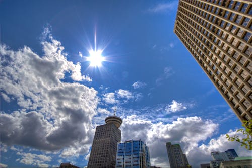 免費 白天在白色和灰色多雲的藍天下的摩天大樓的低角度攝影 圖庫相片