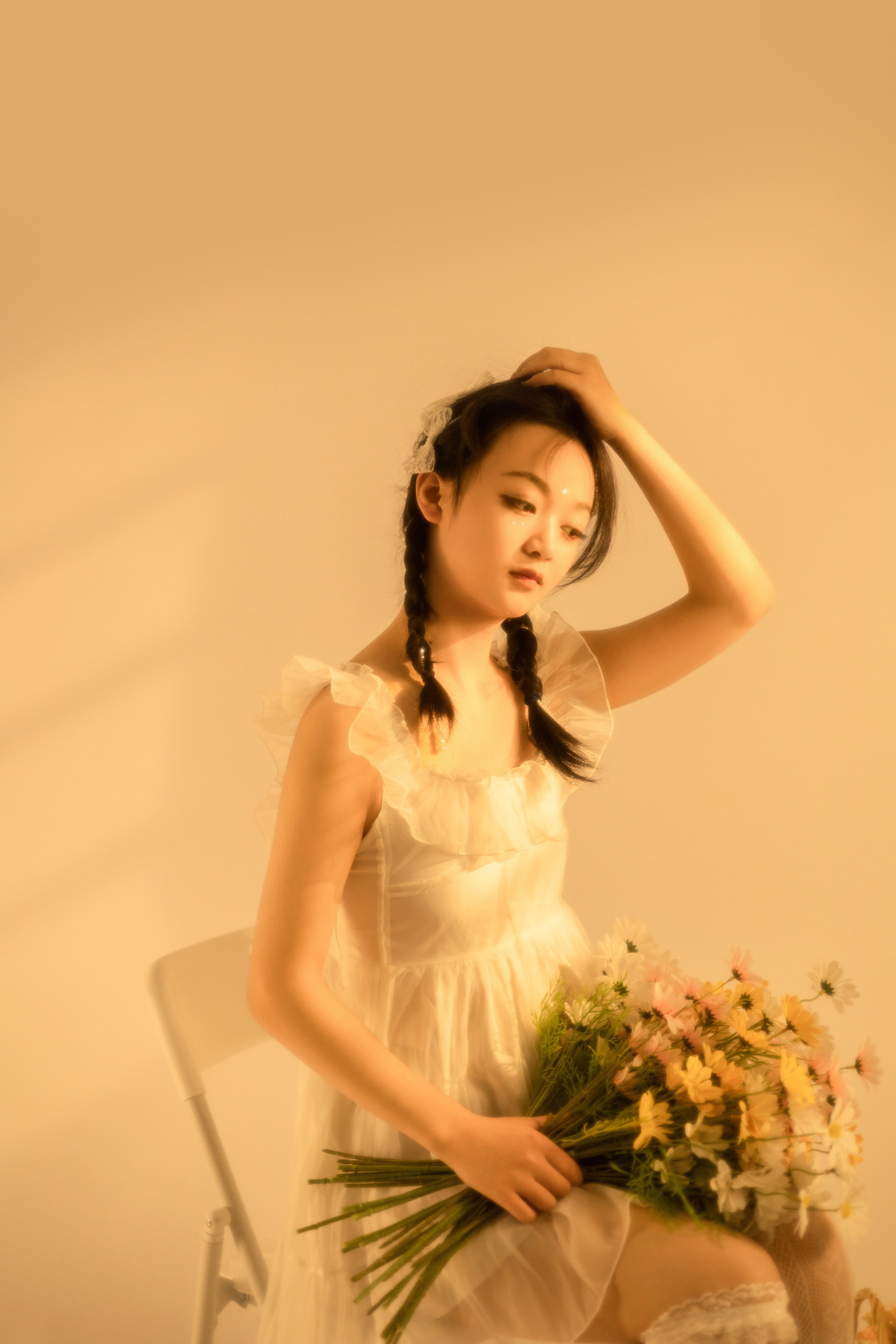 Young Woman in a White Dress Holding a Bunch of Flowers · Free Stock Photo