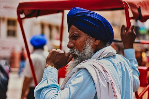 Free A senior Sikh man in traditional attire with a turban in Amritsar's vibrant street scene. Stock Photo