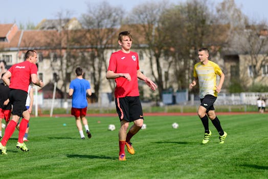 Young men practicing soccer on a sunny day at an outdoor field, focusing on exercise and teamwork.