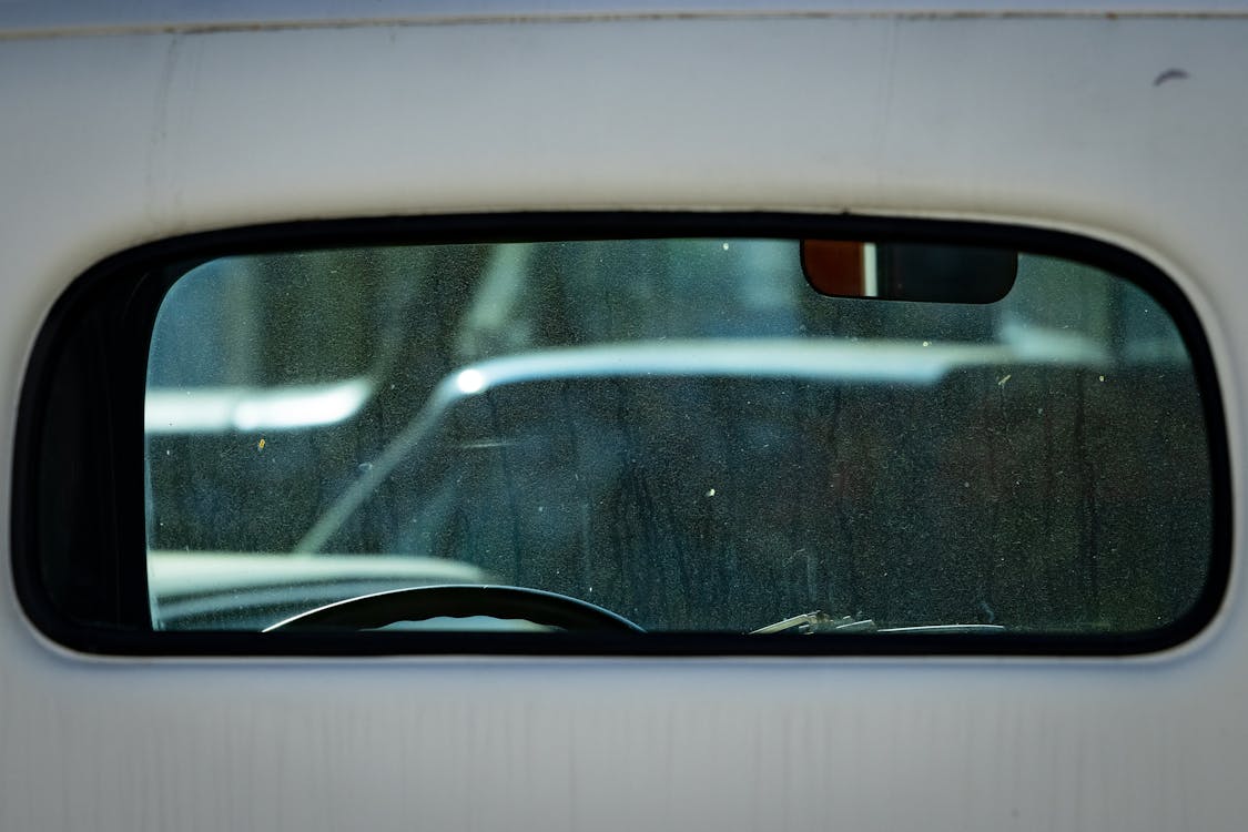 Rear-View Mirror Seen through the Back Window of a Car · Free Stock Photo